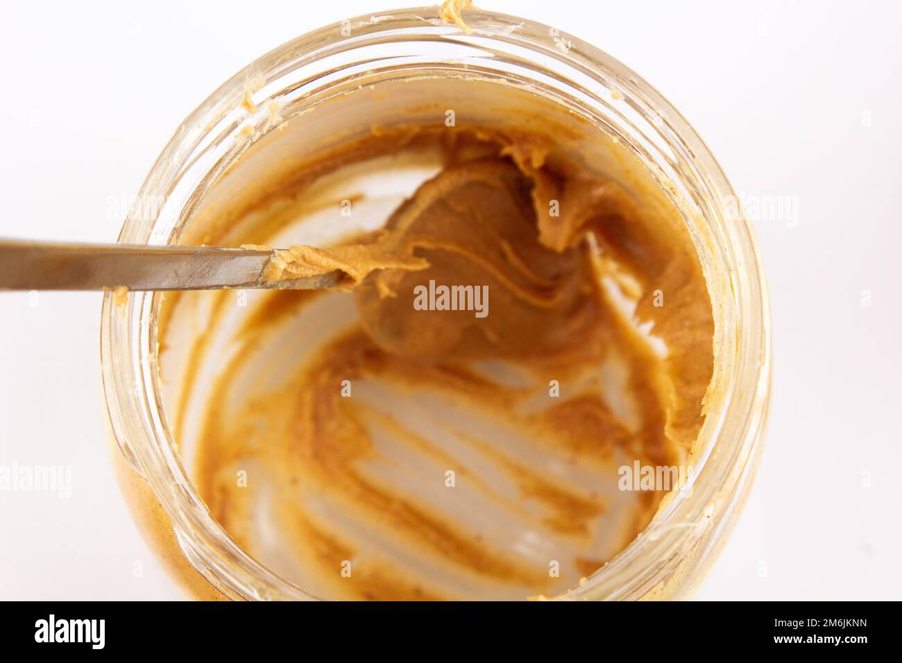 Peanut butter in an open jar. Empty peanut butter container. The last