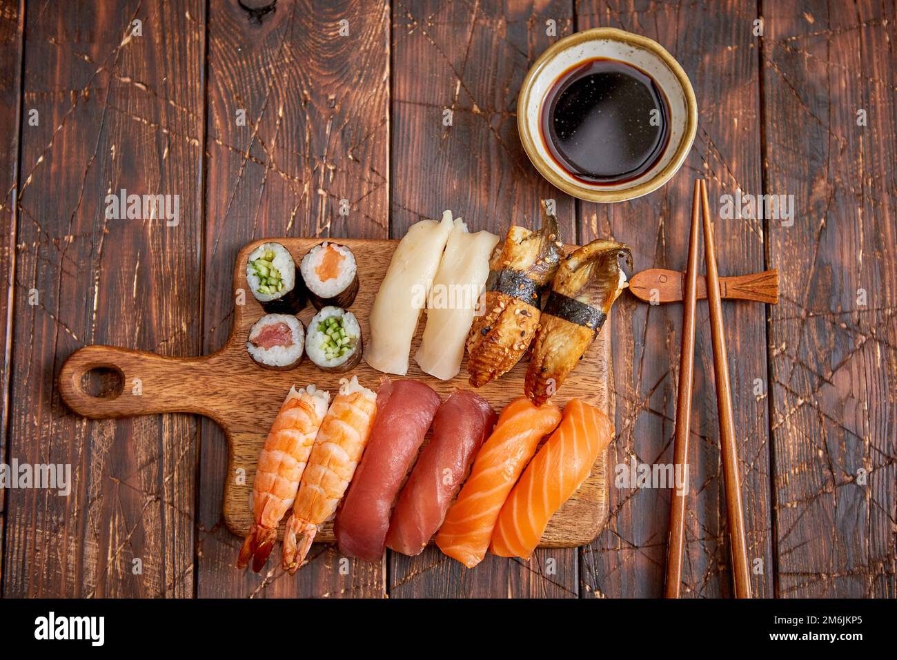 https://c8.alamy.com/comp/2M6JKP5/sushi-set-different-kinds-of-sushi-rolls-on-wooden-serving-board-2M6JKP5.jpg