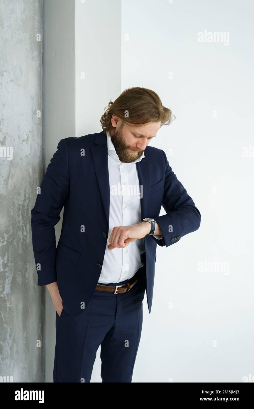 A handsome brutal bearded and long-haired man, a stylish businessman on a white background Stock Photo