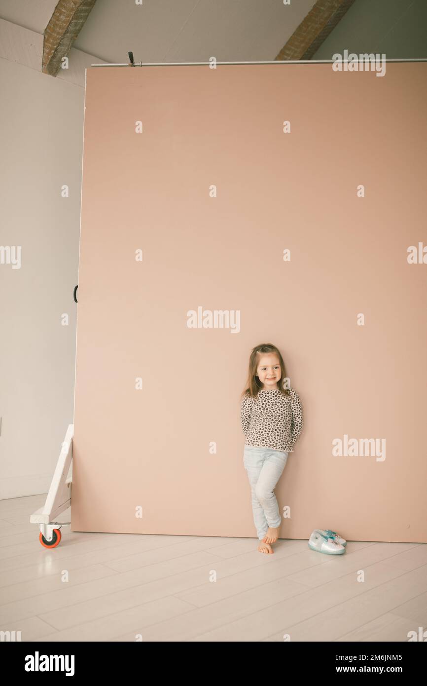Little girl posing in a cheetah shirt against a pink backdrop wa Stock Photo