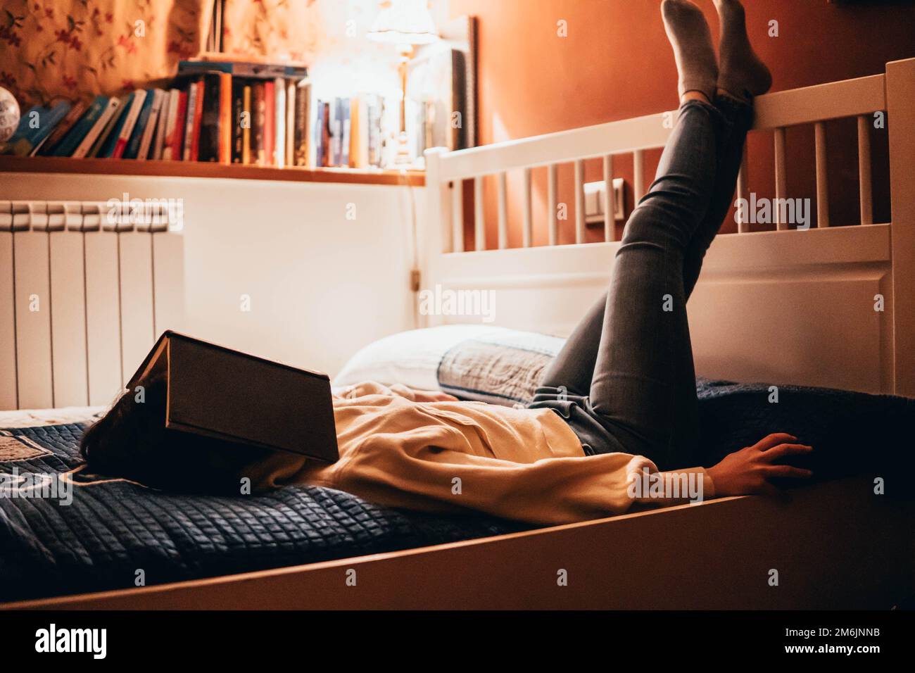 woman reading a book lying in bed at night Stock Photo Alamy