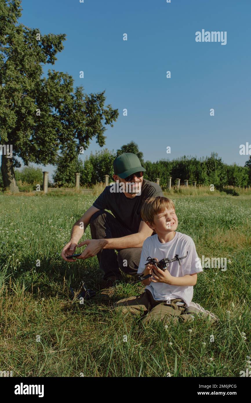 Father and son playing with flying drone, family Stock Photo - Alamy