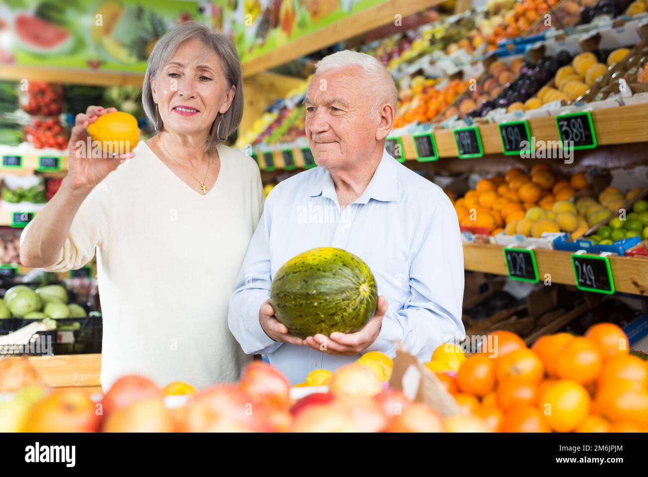 Mature woman and man selecting fruits in greengrocer Stock Photo - Alamy
