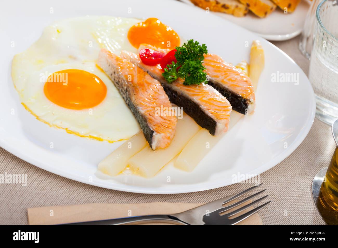 Fried salmon with scrambled eggs and asparagus Stock Photo