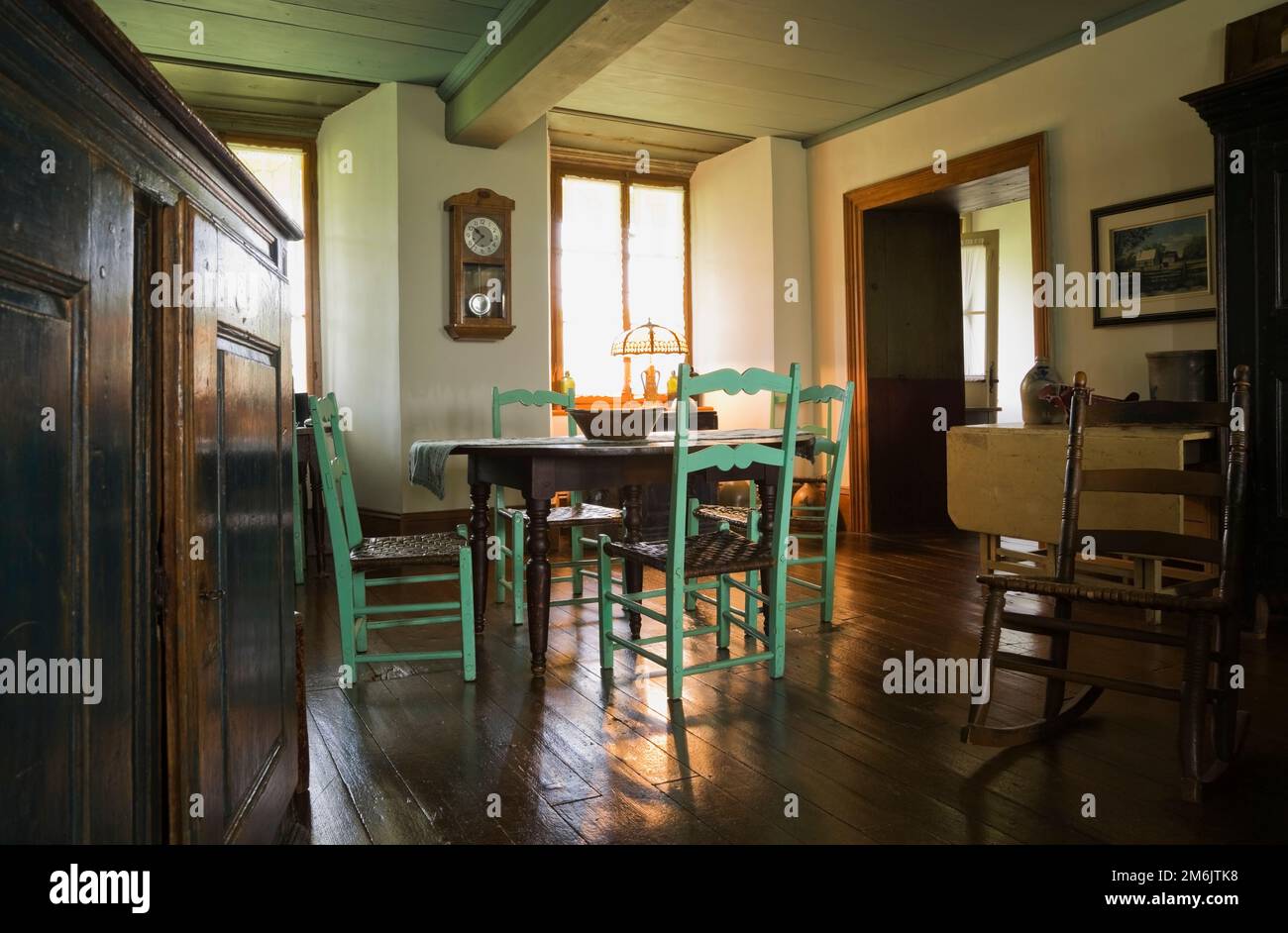 Old brown wooden antique oval table and high back green chairs in 2nd