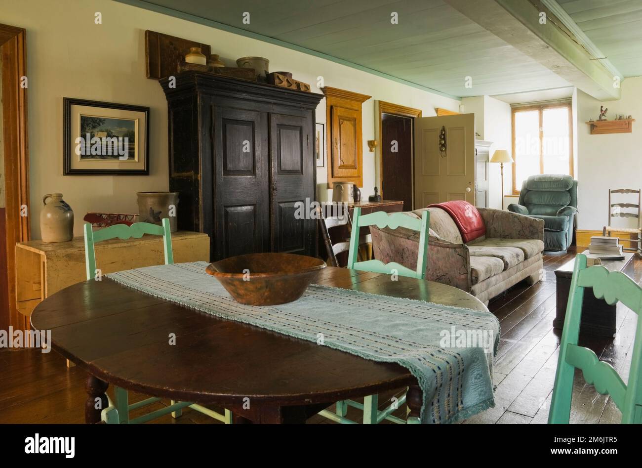 Old brown wooden antique oval table and high back green chairs in 2nd