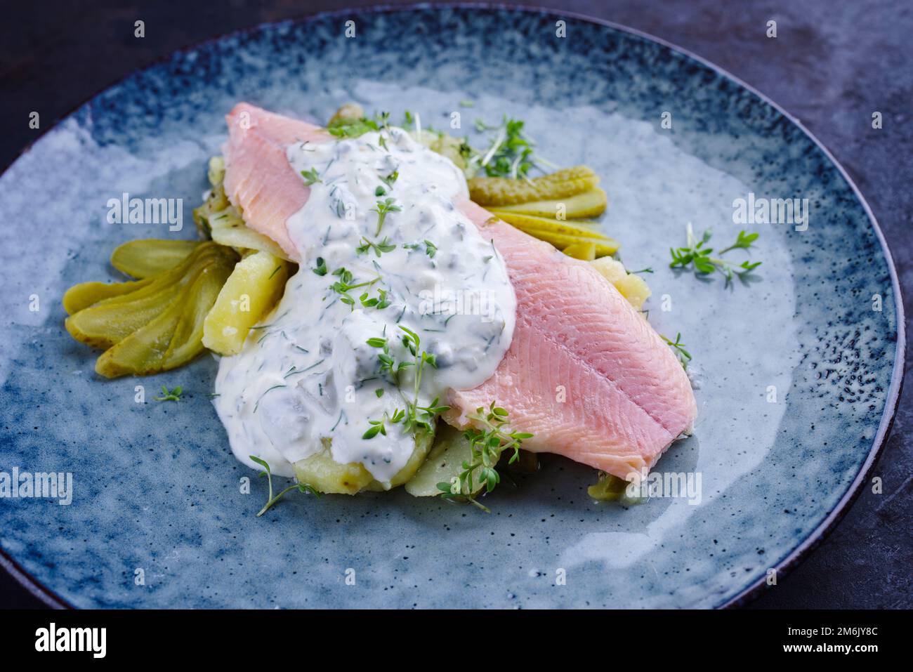 Modern style traditional smoked rainbow trout with boiled potato salad