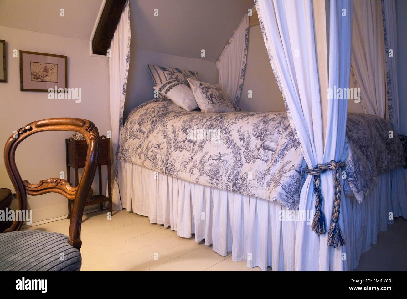 Antique wooden chair and double size canopy bed in bedroom on upstairs  floor inside old 1809 cottage style home, Quebec, Canada. This image is  proper Stock Photo - Alamy