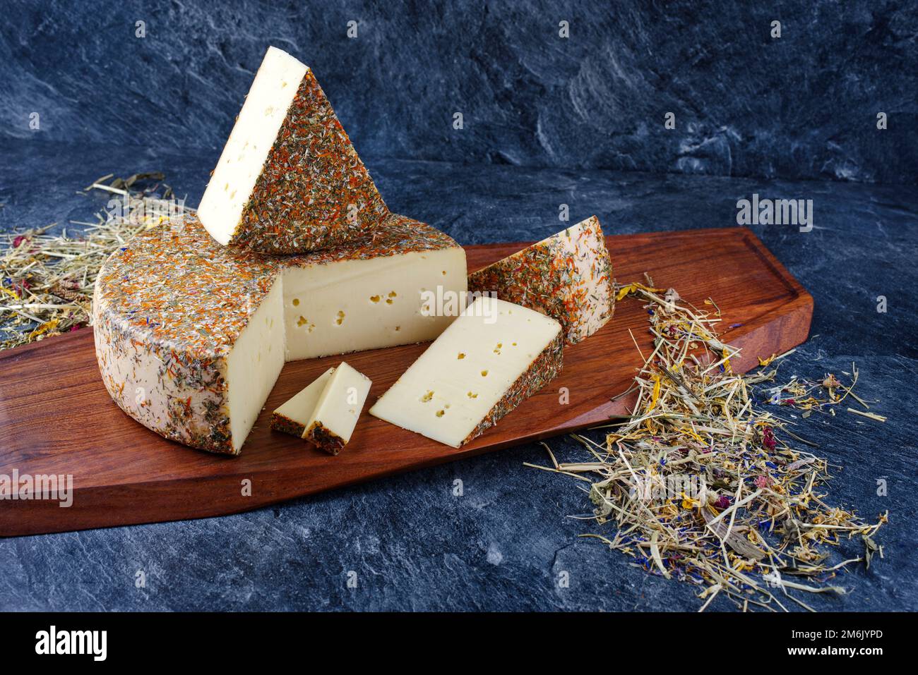 Traditional aged hay flower mountain cheese of the Alps offered as loaf
