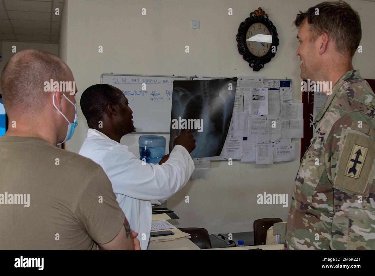 U.S. Army Capt. Matthew Gomberg, right, a battalion physician assistant assigned to Headquarters and Headquarters Company, 3rd Battalion, 126th Infantry Regiment (3-126th IN), and  Staff Sgt. James Dewitt, both with the Michigan National Guard (MING), look at X-Rays with Liberian Dr. Edwin N. Sumowar, emergency medicine specialist, at 14 Military Hospital in Monrovia April 29, 2022. MING's State Partnership Program with Liberia was on full display as various medial units conducted a medical 'best practices' exchange in Monrovia April 25-29, 2022, at the hospital. Together with the AFL, MING he Stock Photo