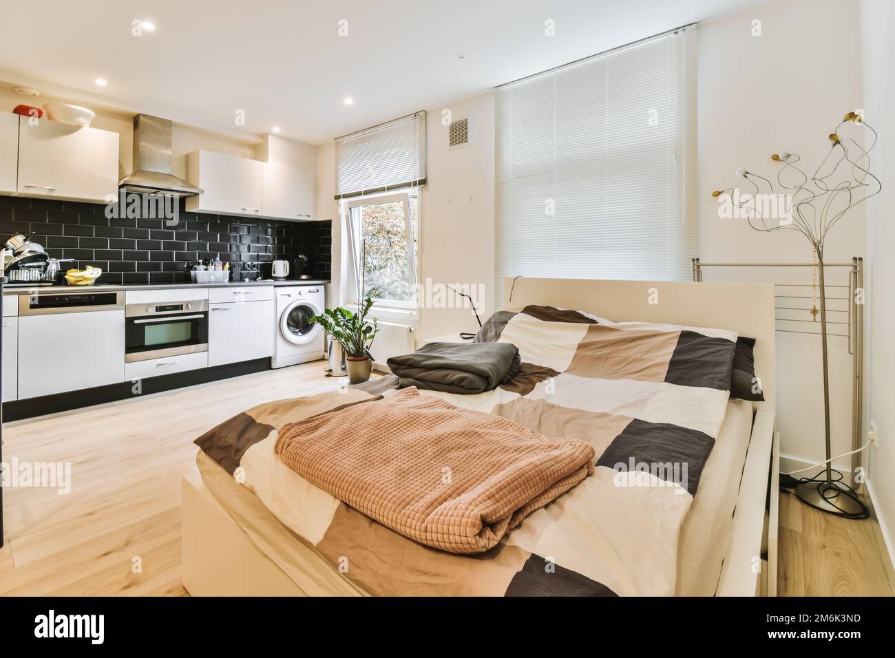 a bedroom with a bed, microwave and oven in the corner next to each