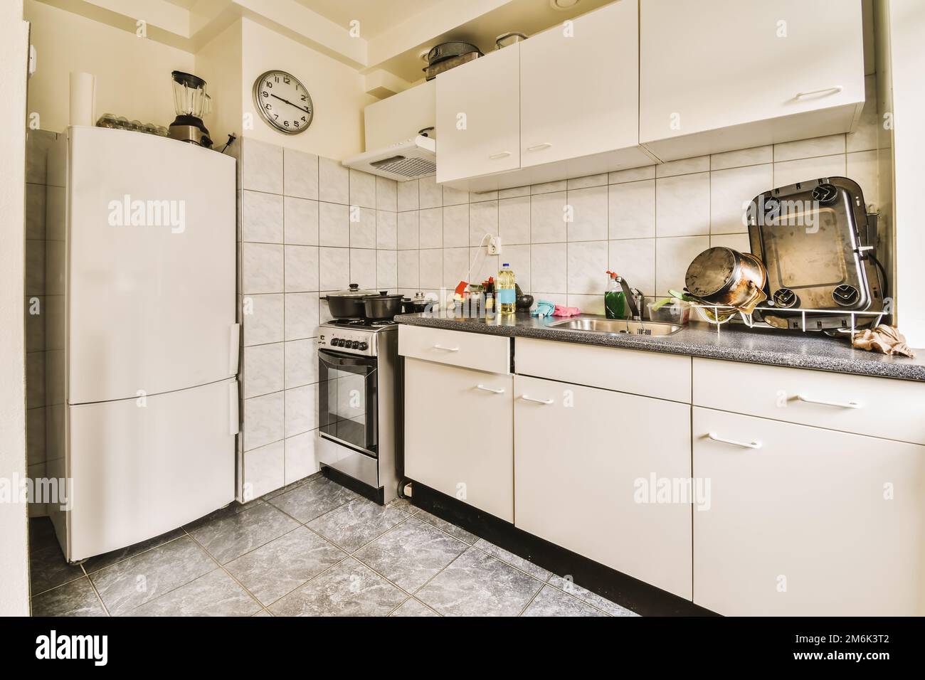 a kitchen with white cupboards and black counter tops on the counters in this photo is taken from the inside Stock Photo