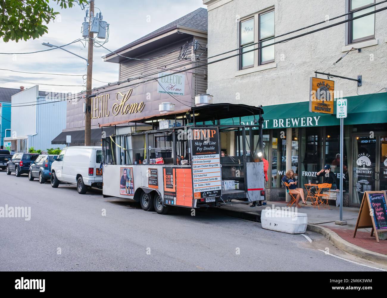 NEW ORLEANS, LA, USA - AUGUST 8, 2022: Cityscape of section of Oak Street with Chef Scott's BBQ food truck, Oak Street Brewery and Eclectic Home Stock Photo