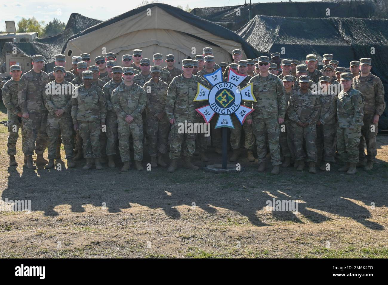 U.S. Soldiers assigned to the brigade staff of 3rd Armored Brigade Combat Team, 4th Infantry Division (3/4 ABCT) pose after concluding a brigade command post exercise, Drawsko Pomorskie, Poland, April 30, 2022. The 3/4 ABCT is among other units assigned to V Corps, America’s forward-deployed corps in Europe that works alongside NATO allies and regional security partners to provide combat-credible forces. Stock Photo