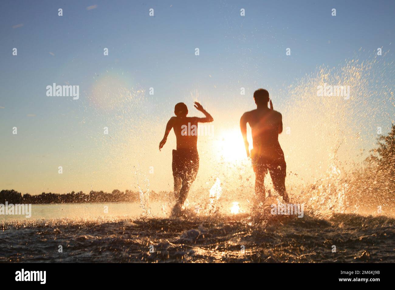 Friends running on beach sunset hi-res stock photography and images - Alamy