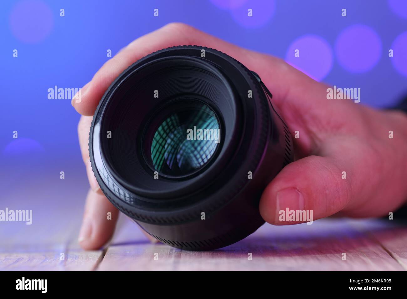 chinese 50mm lens in hand on table and colored background Stock Photo
