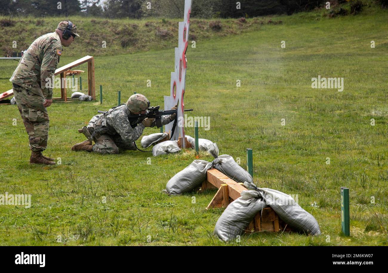 An Oregon Army National Guard Soldier aims his service M4 carbine rifle through a barricade during the Practical Rifle event while participating in the 2022 Adjutant General’s (TAG) Match,  held at Camp Rilea Armed Forces Training Center, Warrenton, Oregon, April 30. Over the course of three days, Soldiers and Airmen competed in five combat-focused events that demonstrated their proficiency using their service M4 carbine rifle, M9 pistol, and a M500 shotgun. Stock Photo