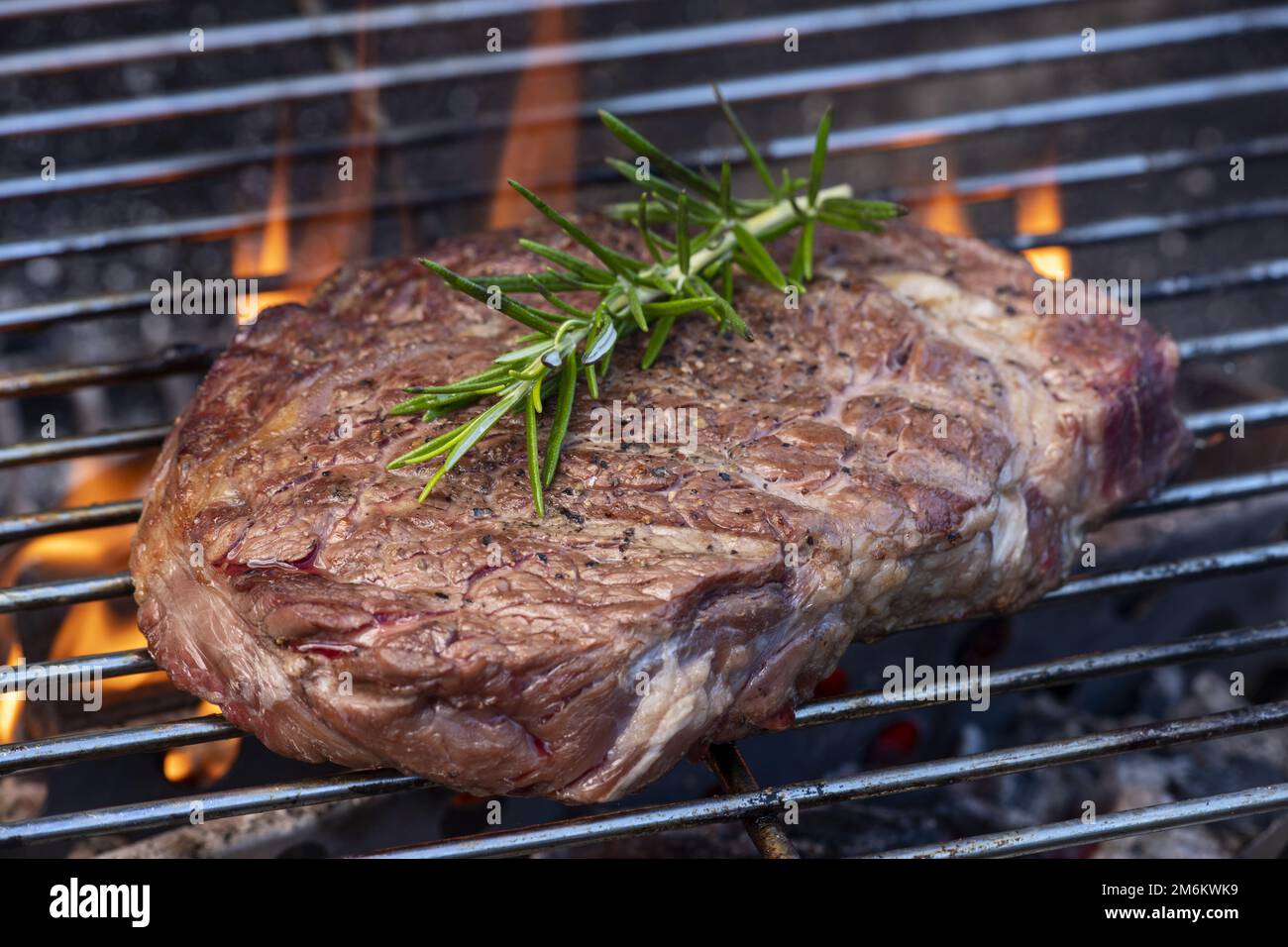 Raw steak with rosemary on the grill Stock Photo
