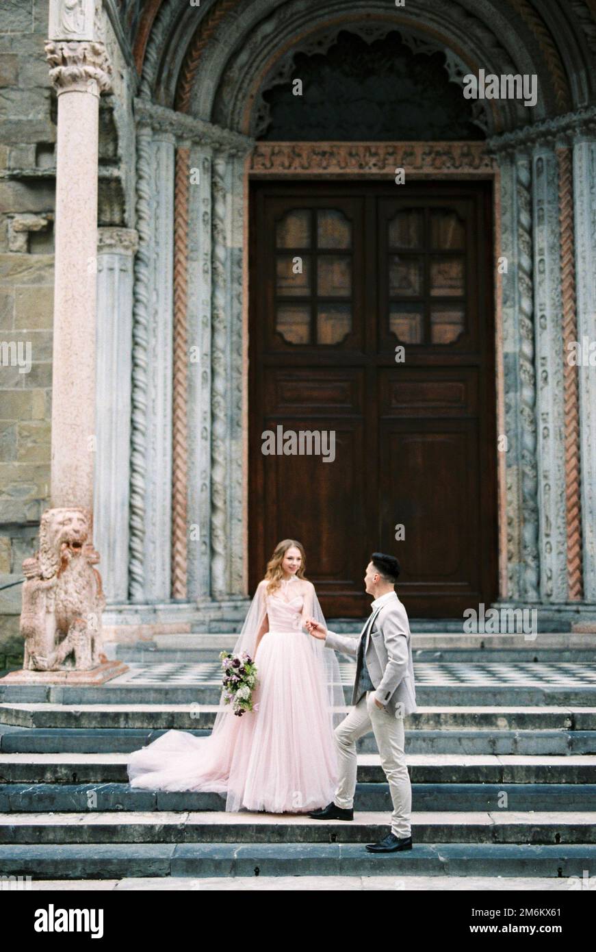 Newlyweds stand on the steps of the church. Bergamo, Italy Stock Photo