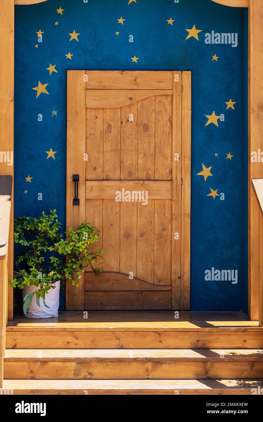 Wooden porch with a door and a blue wall with golden stars. Decorative ...