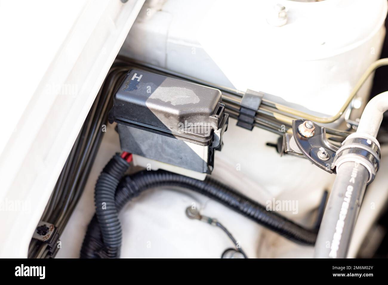 Electric fuse box in car engine bay Stock Photo