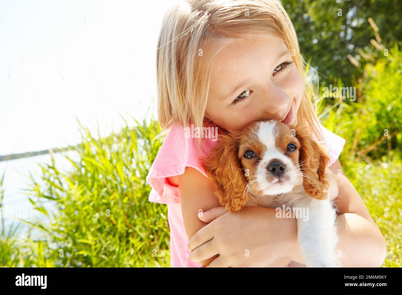 Giving my puppy a big cuddle. a cute little girl hugging her puppy outdoors Stock Photo Alamy