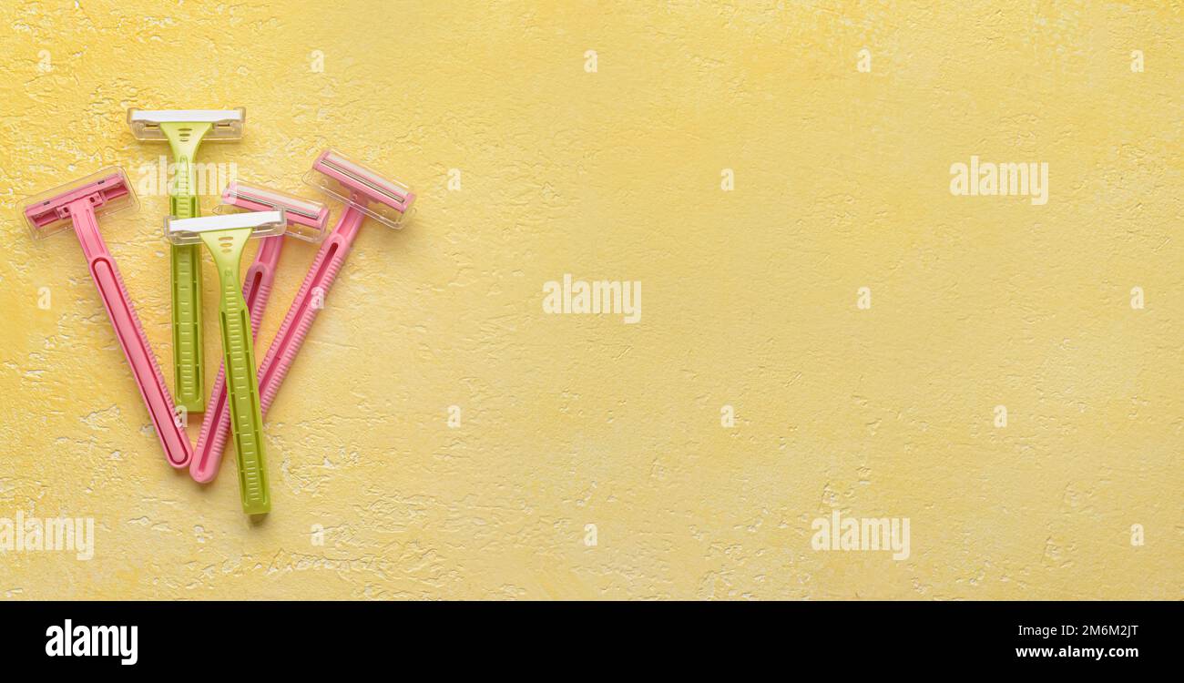 Many different razors for hair removing on yellow textured background ...