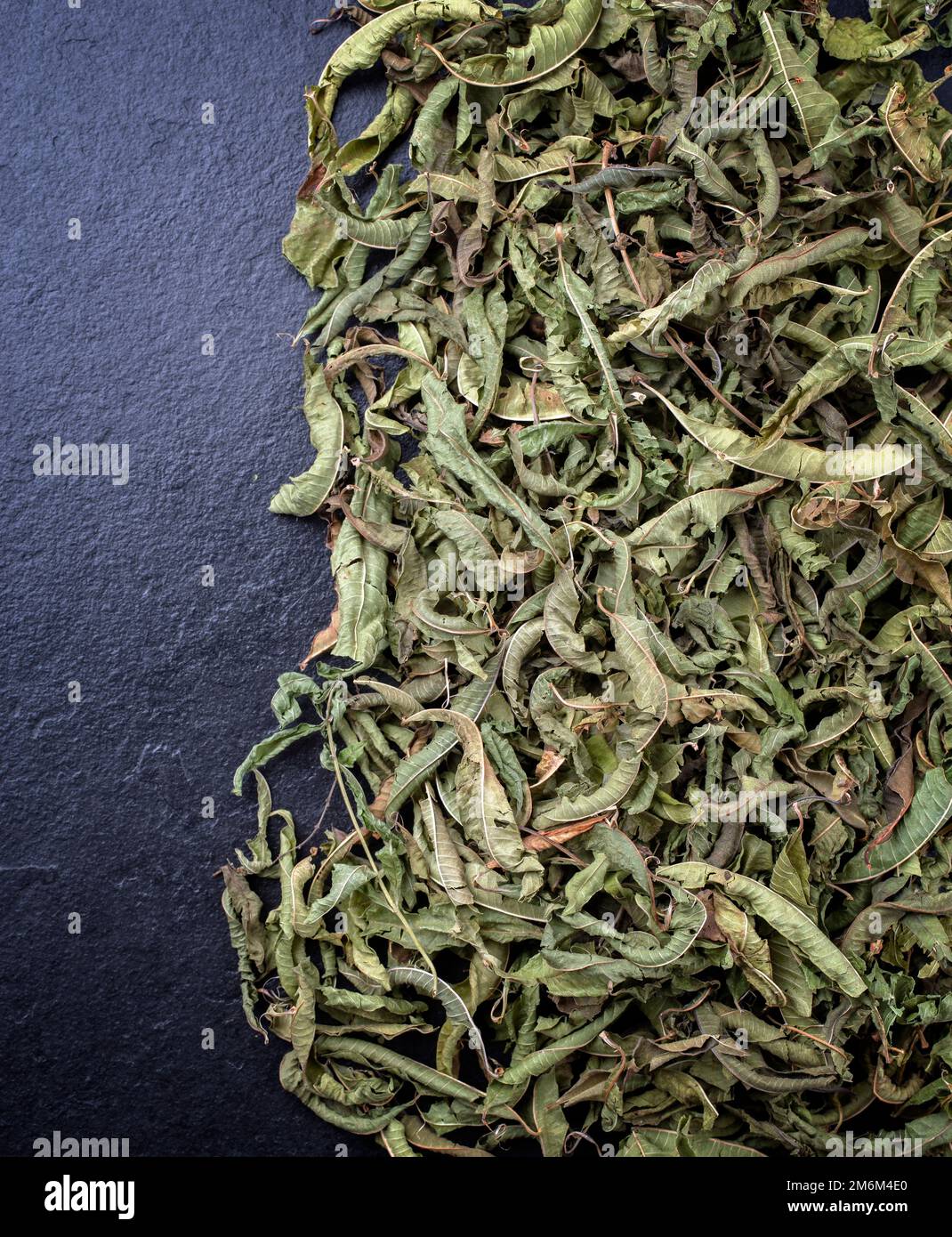 Traditional dried lemon verbena leaves offered as top view on a rustic
