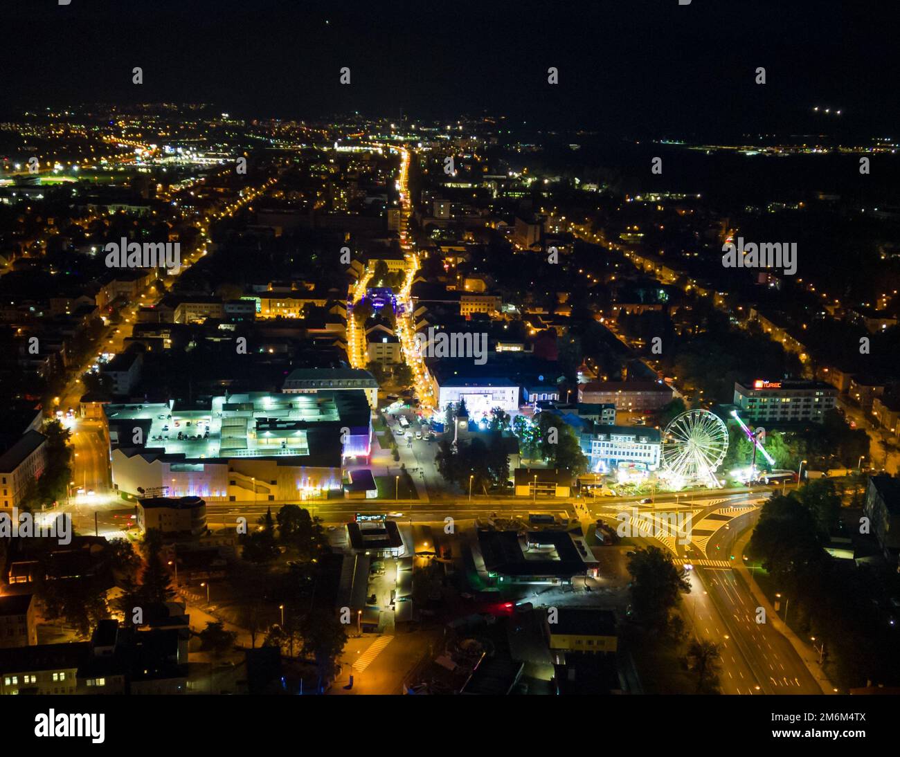 An aerial view of streets and buildings of a city illuminated at night ...