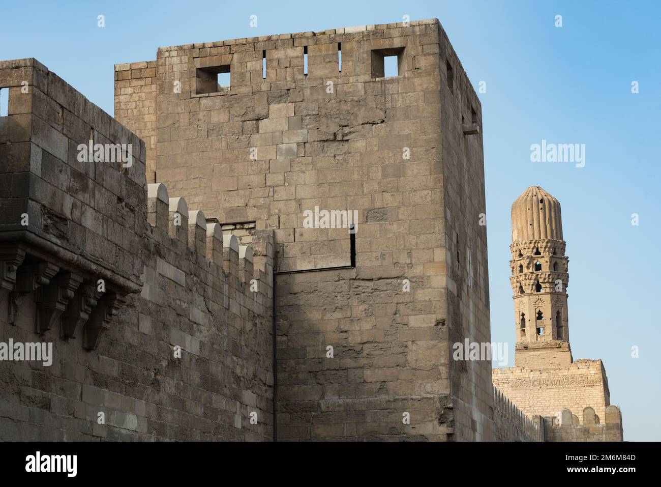 Minaret of the Al Hakim Mosque with the fortified defensive Northern walls of Islamic Cairo, near Bab El Futuh one of the ancient gates of the histori Stock Photo