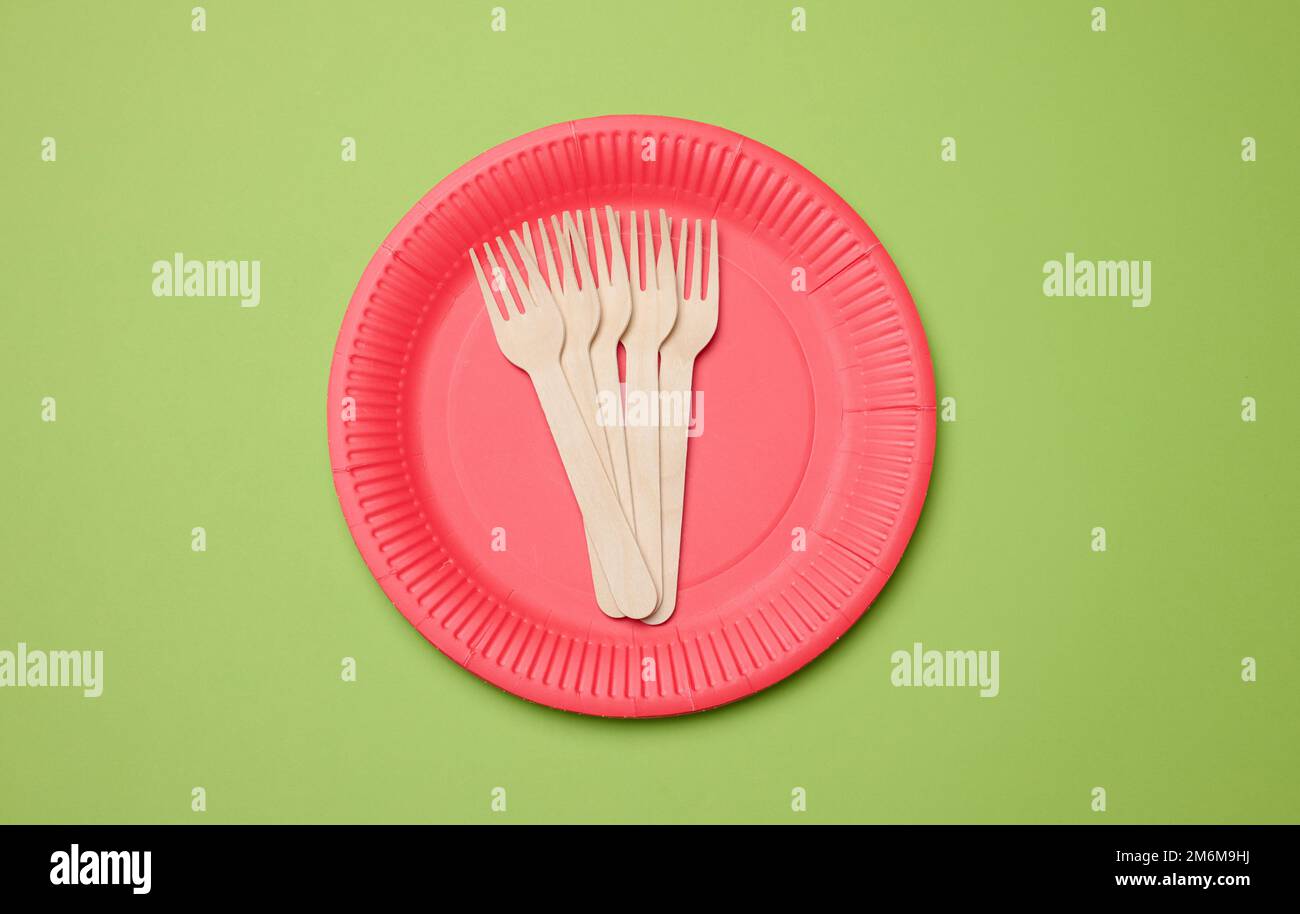 Wooden fork and empty round red disposable plate Stock Photo