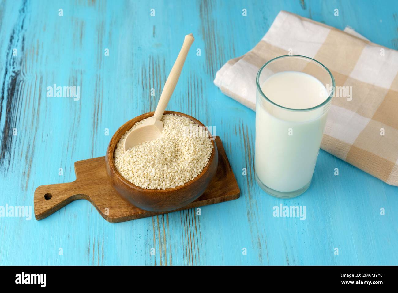 Sesame seed milk in a glass. White sesame seeds on a table. Dairy