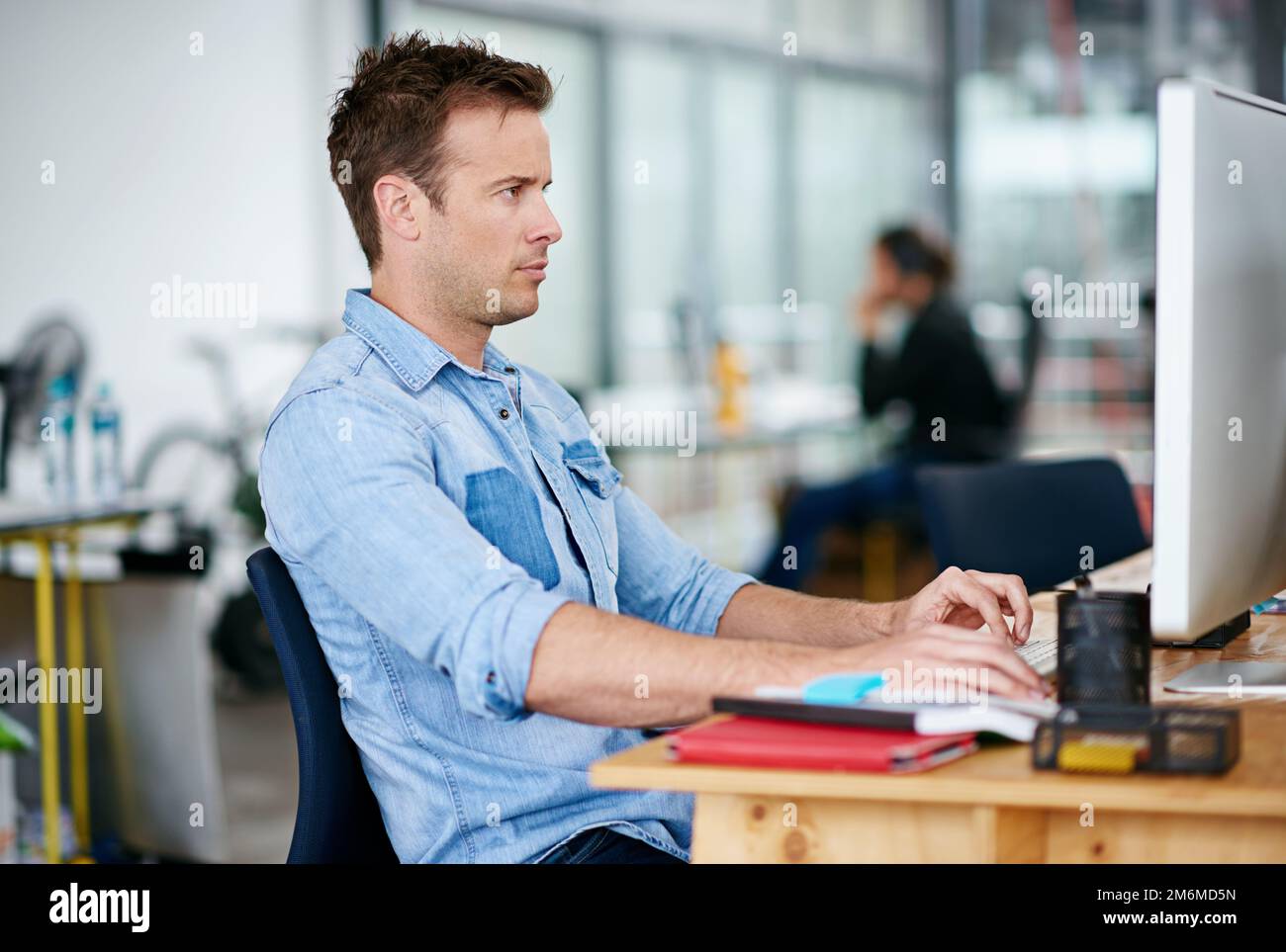 Design online. a handsome young man working at his desk in an office. Stock Photo