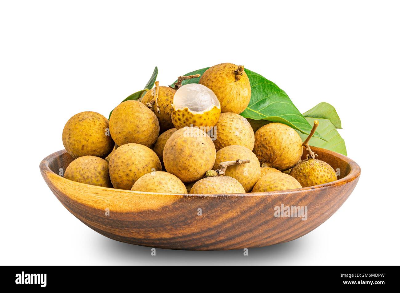 Pile of fresh longan fruit whole and a half peeled with green leaf in wooden bowl isolated on white background. Stock Photo