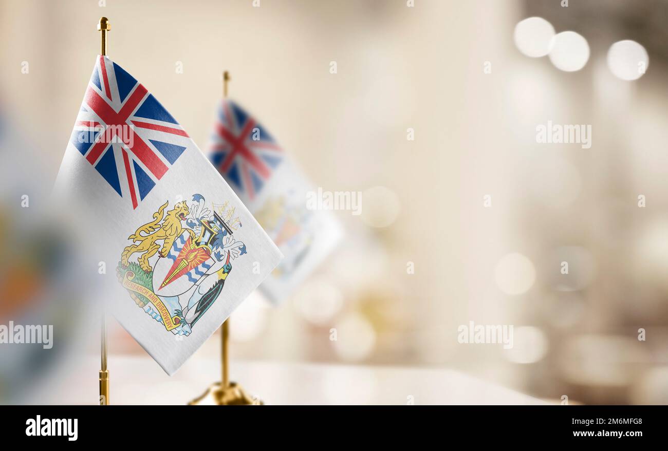 Small flags of the British Antarctic Territory on an abstract blurry background. Stock Photo