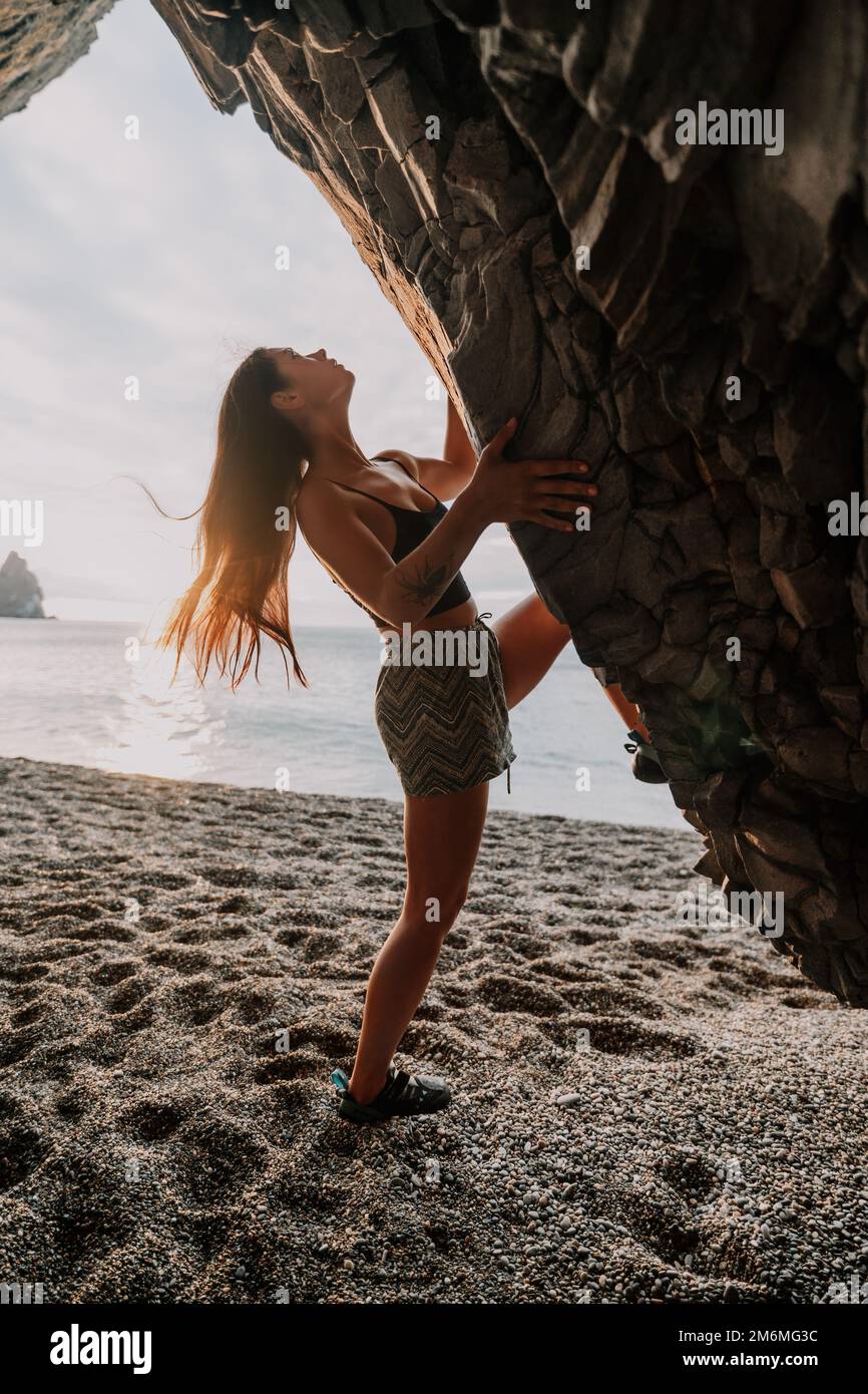 Sports Woman Climbing The Rock. Young woman With slim fit body c Stock Photo