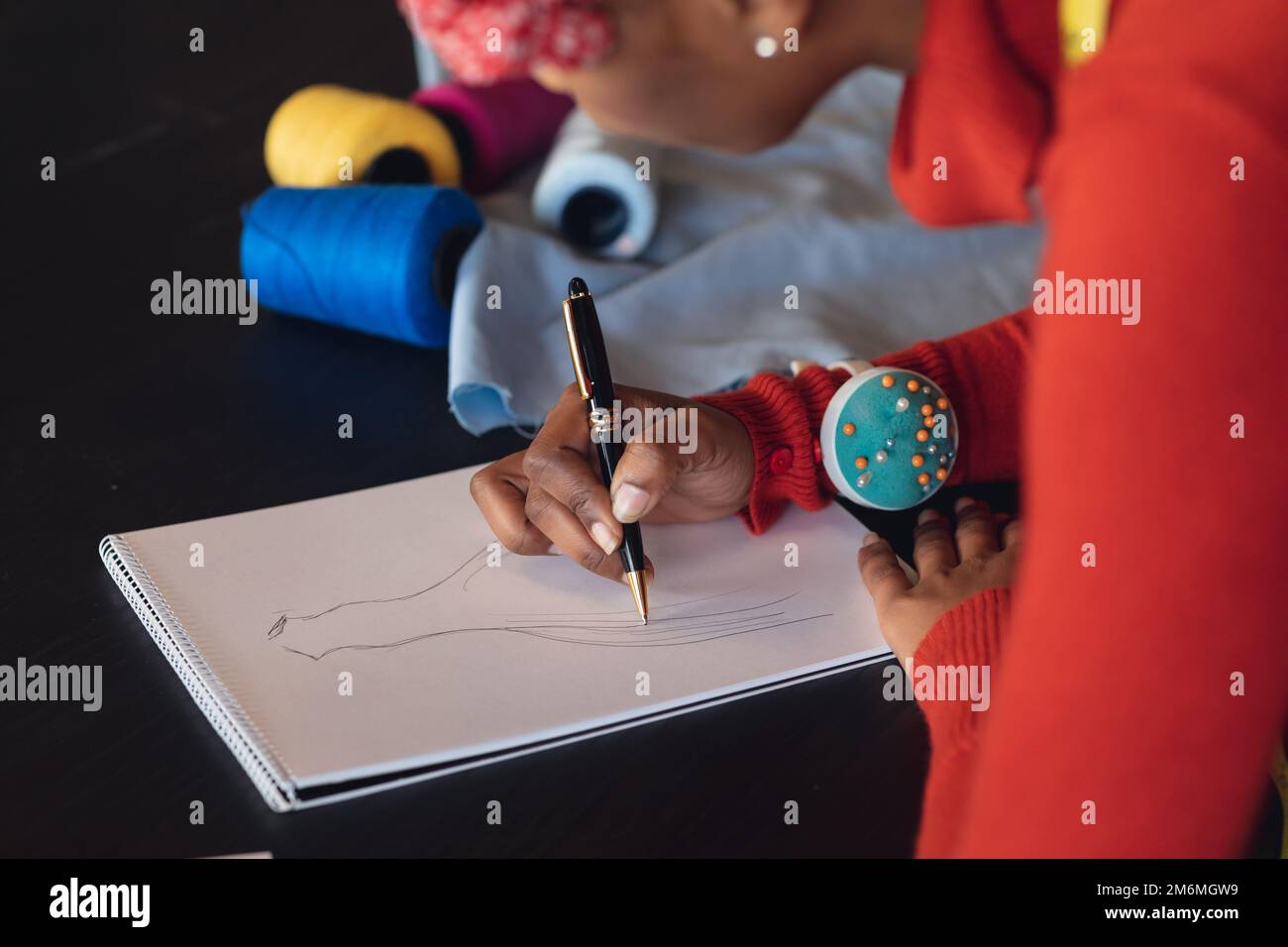African american young female fashion designer drawing sketch at studio ...