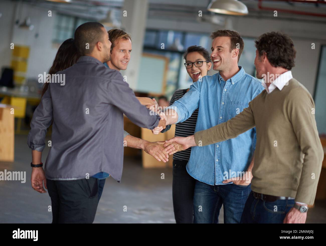 Creative collaborations. Two groups of professional greeting and shaking hands. Stock Photo