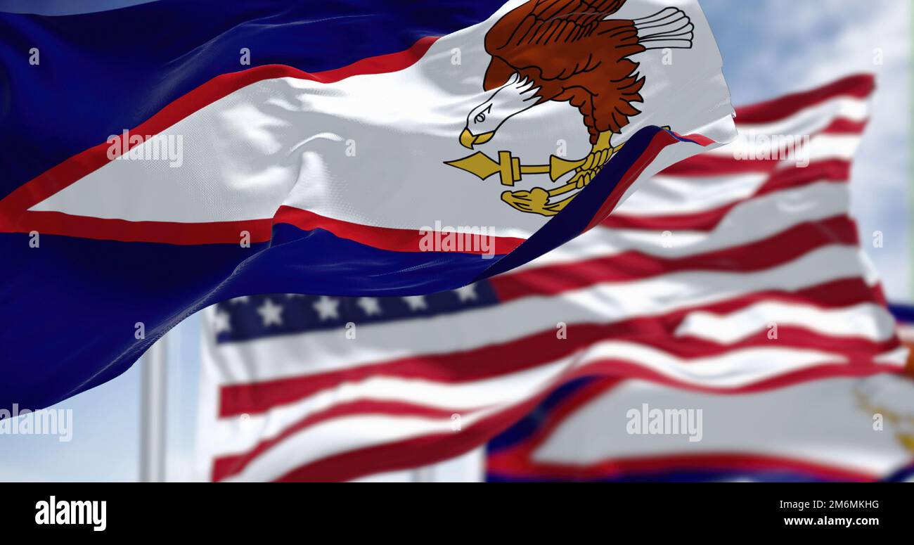 The American Samoa flags waving along with the national flag of the USA Stock Photo