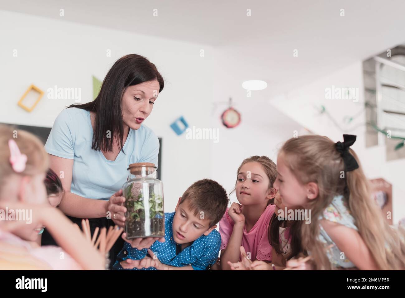 Female Teacher with kids in biology class at elementary school