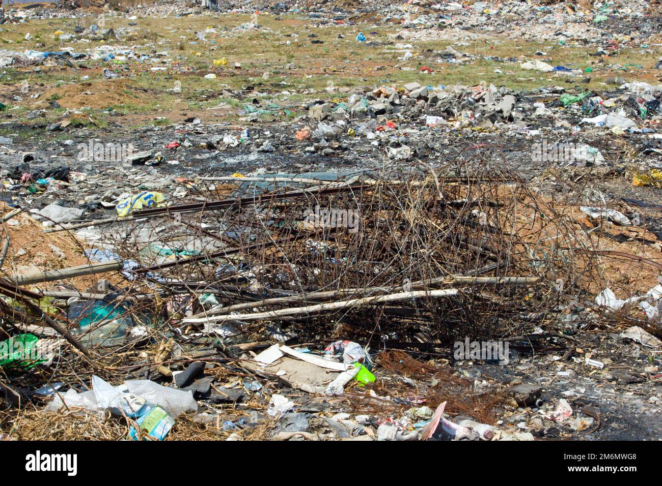 stock photo of rusted wire roll on waste dump site amongst plastic and