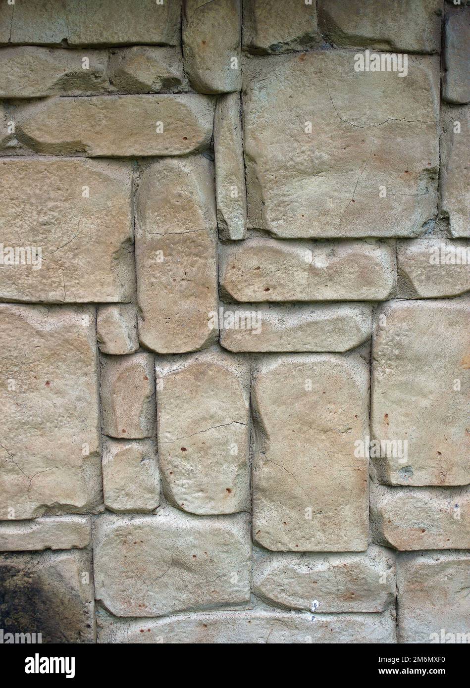 Light brown stones of varying sizes built into a wall, can be used as background Stock Photo