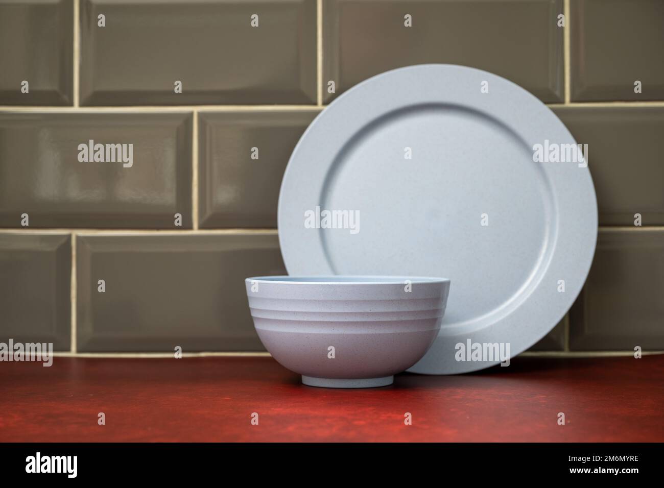 blue composite lightweight material camping dinner ware stacked in the kitchen on a red linoleum work top Stock Photo