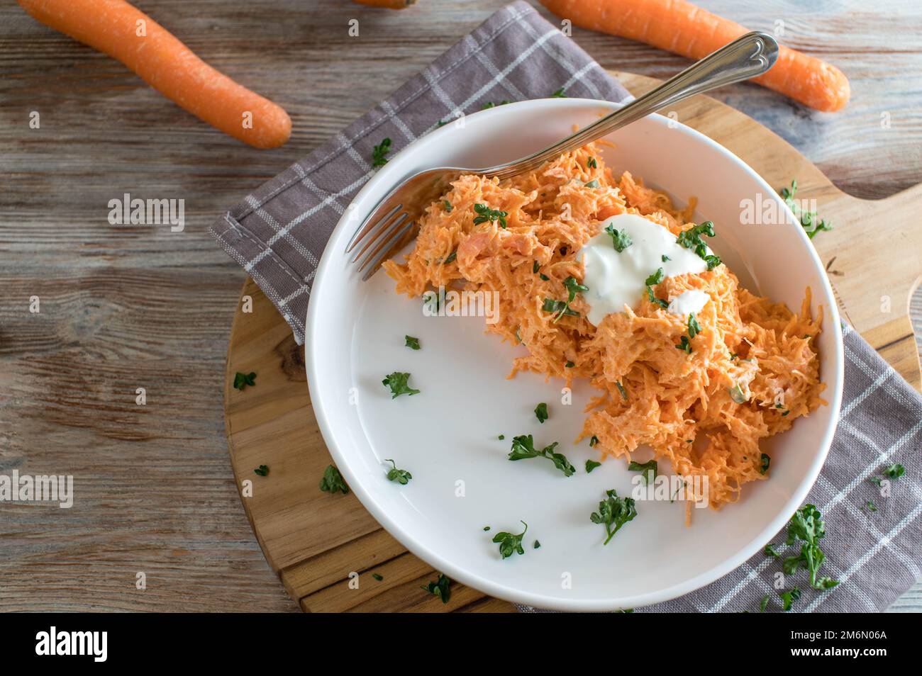 Carrot salad with yogurt dressing on wooden table with space for text Stock Photo