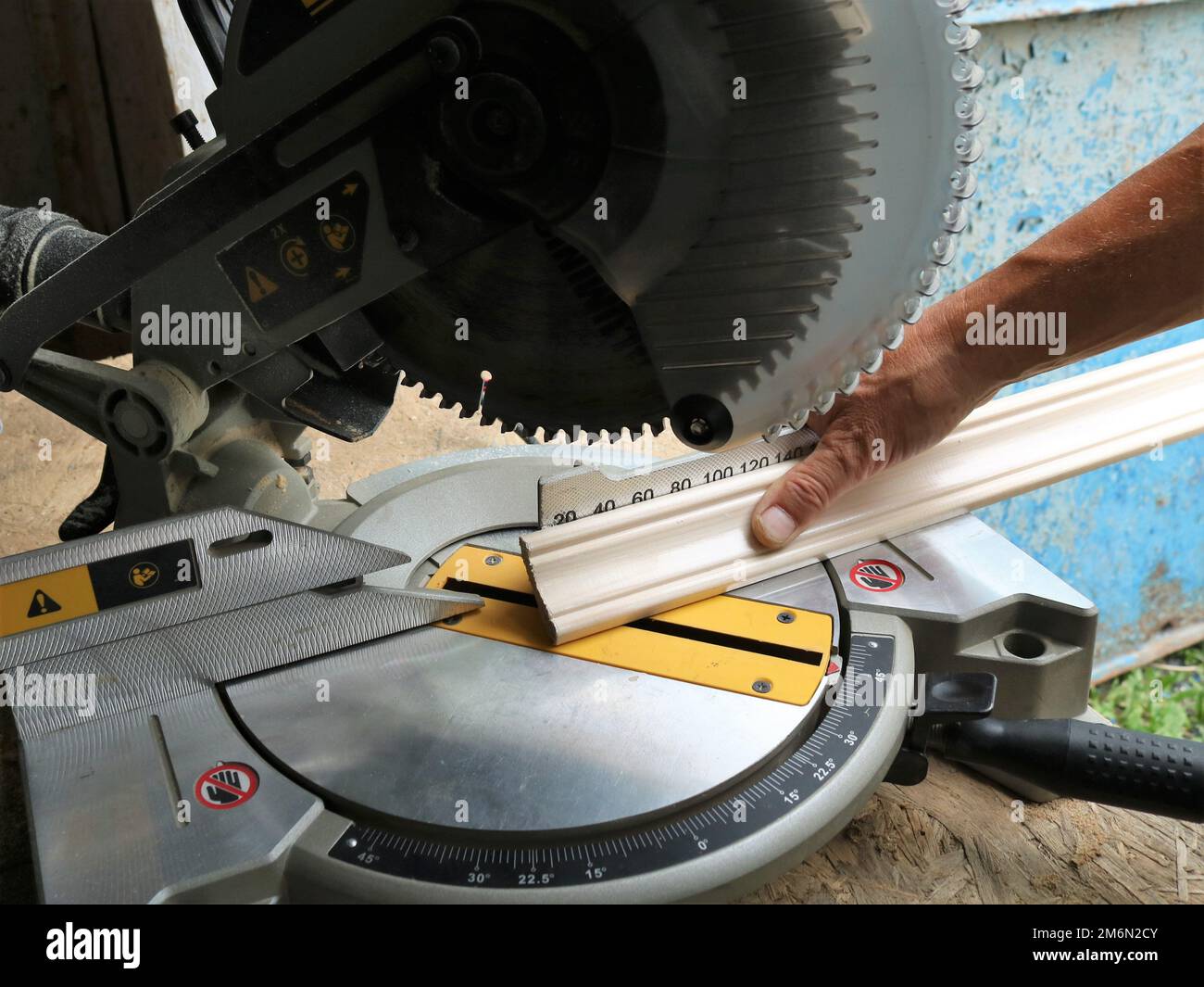 marking and cutting wooden planks on a miter saw, an angle saw in a