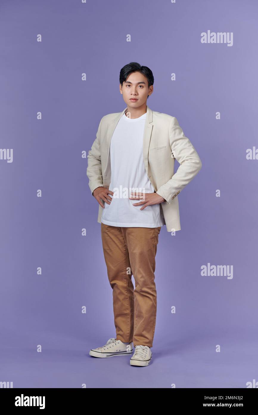 Full length portrait of young handsome southeast Asian millenial businessman on purple Stock Photo