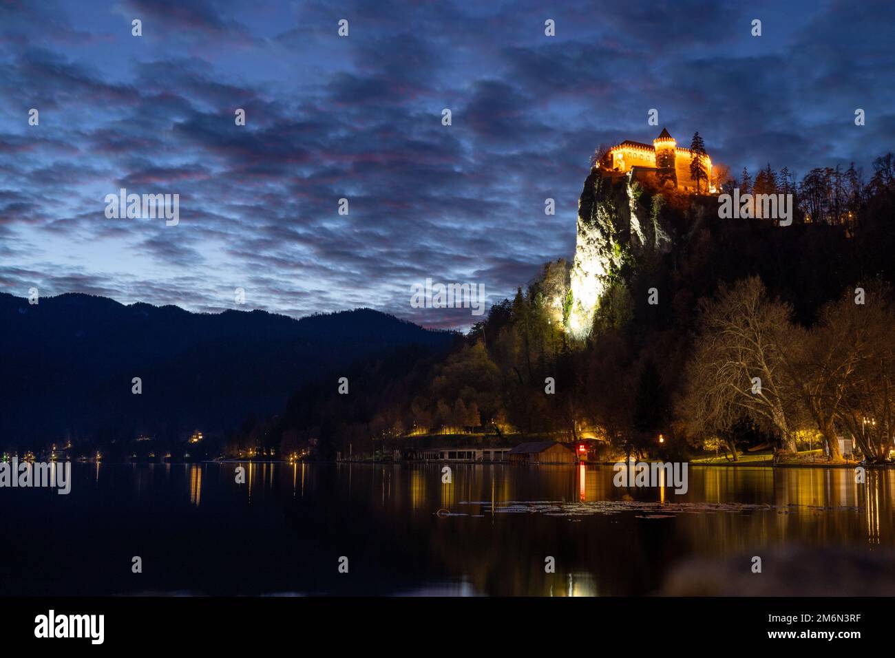 Dramatic cloudscape over medieval castle of Bled perched on cliff above ...