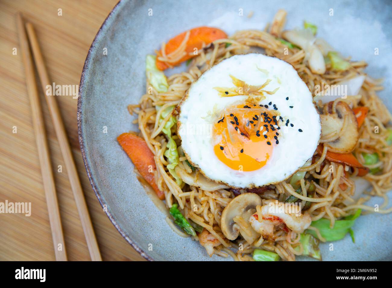 Yakisoba noddles with shrimps and egg on the top. Literally "fried noodles", integrated into Japanese cuisine, just like ramen. Stock Photo