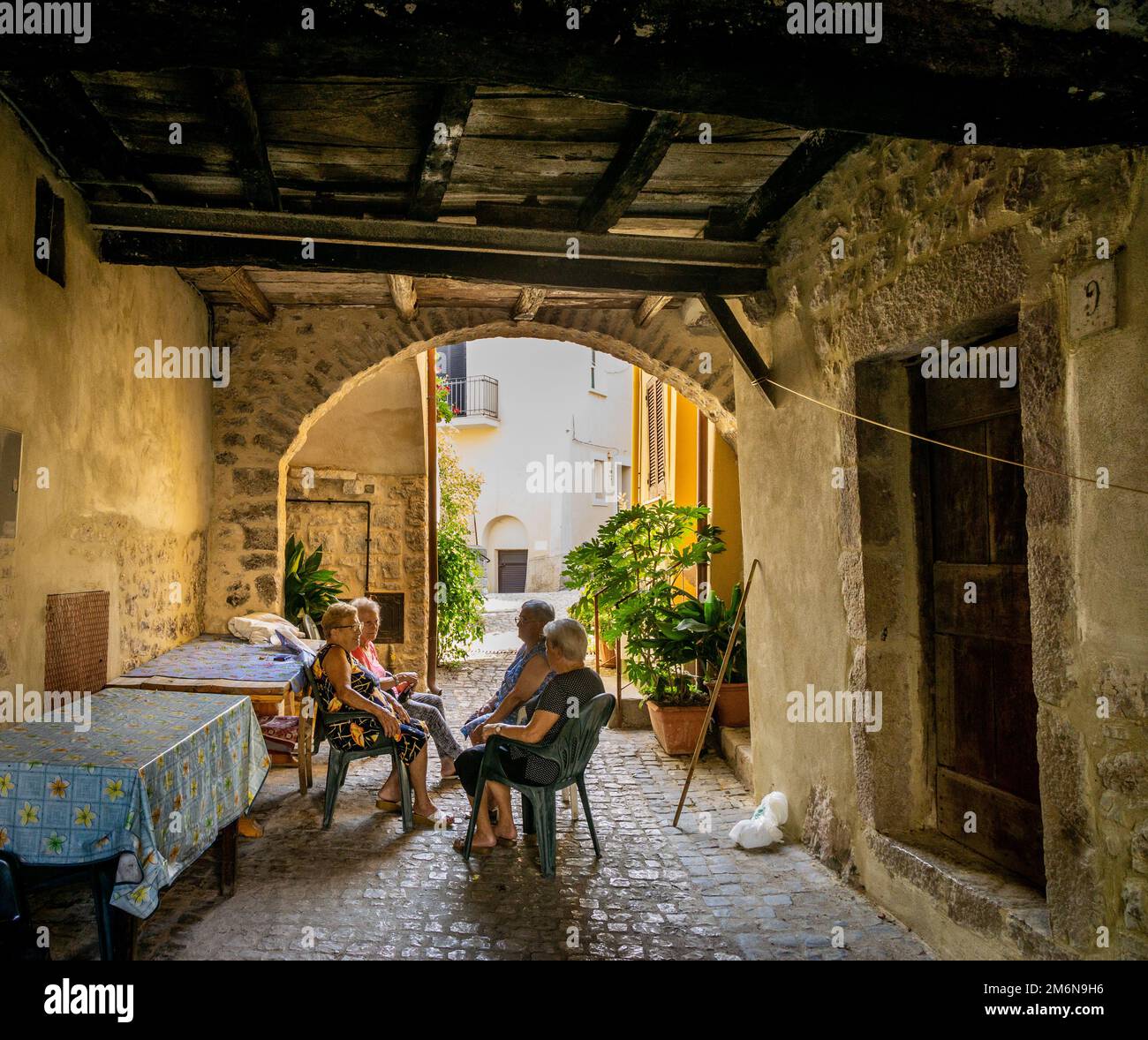 elderly ladies are talking to each other under a portico in Campodimele (Italy). This village is known for the longevity of its residents. Stock Photo
