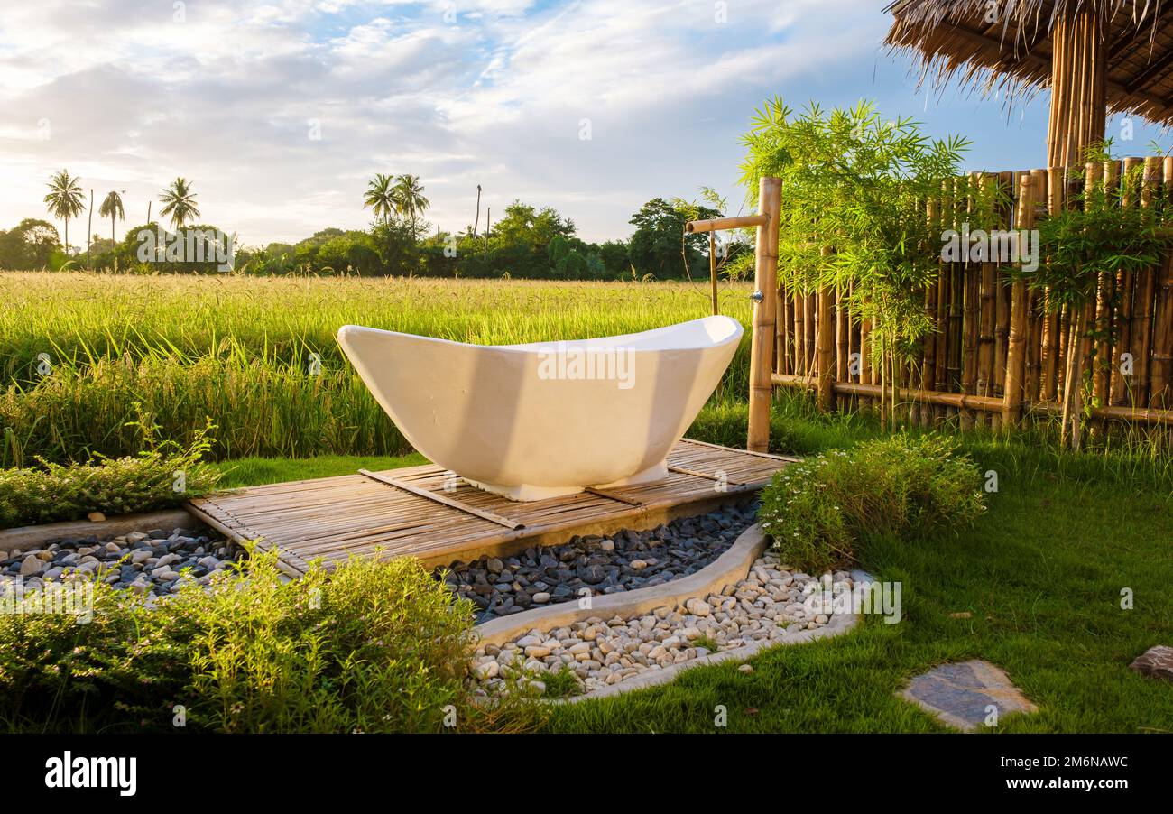 white bathtub outside looking out over a green rice field, bath tub
